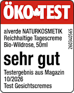 Bildbeschreibung: Weißer Tiegel mit rotem Deckel. Auf dem Etikett steht „alverde NATURKOSMETIK Reichhaltige Tagescreme Bio-Wildrose, 50 ml“. Der Aufdruck „sehr gut“ ist groß hervorgehoben. Darunter: „Testergebnis aus Magazin 10/2026“ und „Test Gesichtscremes“.